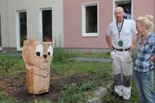 Der Bildhauer Knuth Seim und eine der von Jugendlichen gefertigten Holzskulpturen
